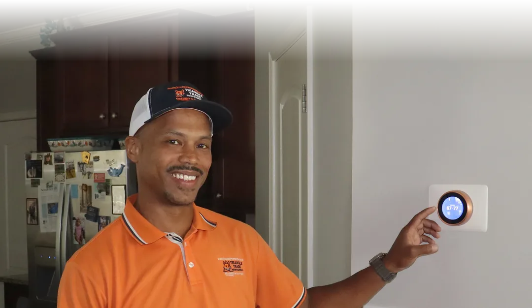 Joel Verley smiling beside a glowing smart thermostat